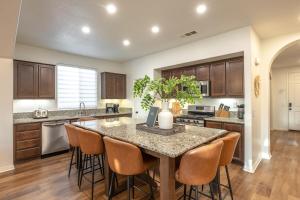 Una cocina con una gran isla con taburetes de bar. en Amara Villa-Heated Pool and Spa, Game Room, Fire Pit, BBQ, en Indio