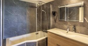 a bathroom with a tub and a sink and a shower at Best Western Côte des Sables Plouescat in Plouescat