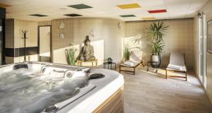 bagno con vasca e statua. di Best Western Côte des Sables Plouescat a Plouescat