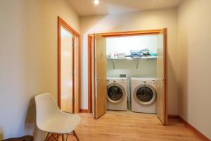 a laundry room with a washer and dryer and a chair at ALOFT in Hood River