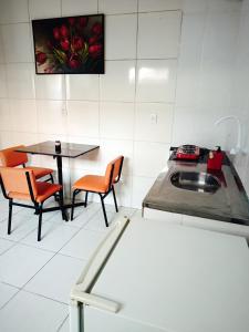 una cucina con un lavello, un tavolo e delle sedie di Micro Casas, Próximas ao Terminal Rodoviário, Mercado de São Brás - 1 Unidade disponível para COP 30 a Belém