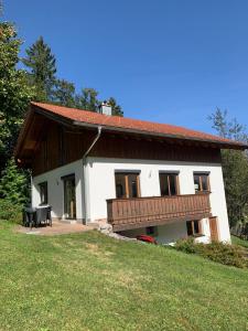 a large white house with a balcony and a yard at Ferienhaus Baumberger in Oberammergau