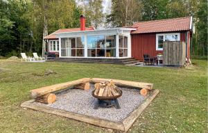 a house with a fire pit in the yard at 3 Bedroom Beautiful Home In Vissefjärda in Vissefjärda