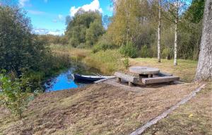 a picnic table next to a river with a boat at 3 Bedroom Beautiful Home In Vissefjärda in Vissefjärda