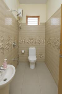 a bathroom with a toilet and a sink at Bhakti Bliss Homestay - New Luxury 2bhk apartment in Tirupati with Kitchen and car parking in Tirupati