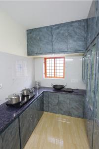 a kitchen with a counter with pots and pans on it at Bhakti Bliss Homestay - New Luxury 2bhk apartment in Tirupati with Kitchen and car parking in Tirupati