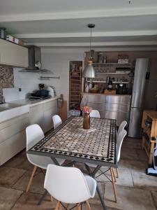 a kitchen with a table and chairs in a kitchen at Benabeach in Sarzeau