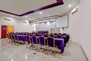 a conference room with purple chairs and a screen at Townhouse Oak Malang near ITN Malang formerly Fariz Hotel Singosari in Malang