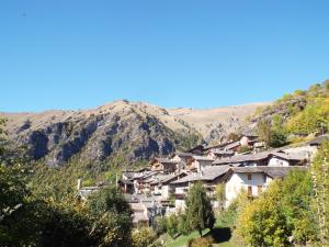 a village on a hill with mountains in the background at Nebin - casa vacanze Valle Maira in Stroppo