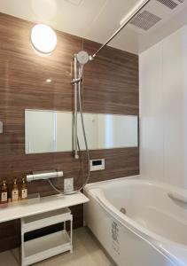 a bathroom with a tub and a sink and a mirror at 大阪第一站 in Osaka