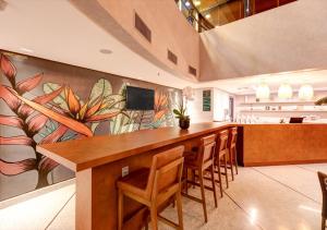 eine große Küche mit einer langen Bar mit Stühlen in der Unterkunft Quality Paulista (São Paulo, Jardins) in São Paulo