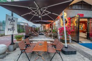 a patio with a table and chairs and an umbrella at Secret Garden Lakefront Hotel 连住两晚享高铁站免费接站 in Guilin