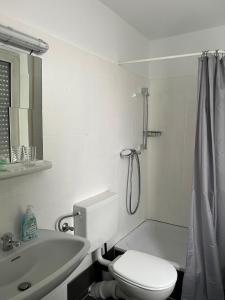 a white bathroom with a toilet and a sink at Art Rock Airport in Cologne +29 photos