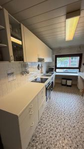 a large white kitchen with a sink and a counter at Deluxe Appartement-Frankfurt Airport in Rüsselsheim