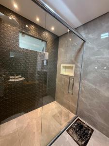 a shower with a glass door in a bathroom at Apê pé na areia in Santos