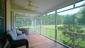 a screened porch with a couch and a ceiling fan at The Still Pond Inn in Still Pond