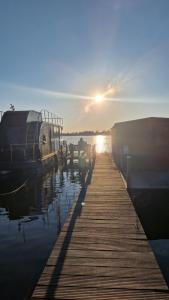 a dock with a boat in the water at sunset at Seeblick Hausboot Sambesi in Königs Wusterhausen