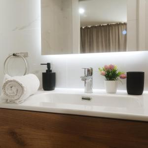 a bathroom sink with a towel and flowers on it at GO&REST Apartments in Valencia