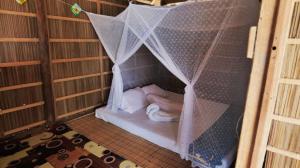 a person sleeping in a bed in a cage at Paradise Raja Ampat in Dayang