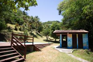 ein kleines Gebäude neben einer Holzbrücke in der Unterkunft Sitio Novo Dia in Saquarema