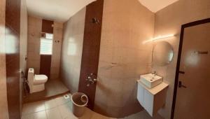 a bathroom with a toilet and a sink and a mirror at Family 3 BHK Residency Top Spots, Falnir Mangalore in Mangalore +14 photos