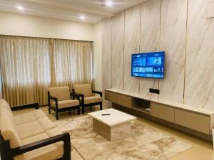 a living room with a couch and a tv at Family 3 BHK Residency Top Spots, Falnir Mangalore in Mangalore