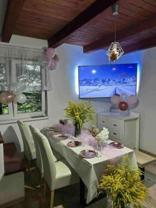 a dining room with a table and a television at Domek nad Jeziorem z Jacuzzi na Mazurach 10os in Jedwabno