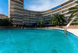 a large swimming pool in front of a building at Gandia Tropicana Suite in Playa de Gandia