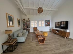 a living room with a couch and a flat screen tv at Villa Ti'Kawet in Pointe-Noire