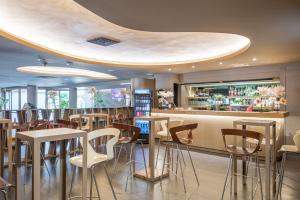 a restaurant with a bar with stools at The Gate Hotel - Firenze Nord in Sesto Fiorentino