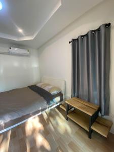 a small bedroom with a bed and a table at บ้านสามฤดู Baansamruedo in Ban Hin Laem +3 photos