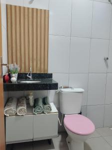 a bathroom with a pink toilet and a sink at Casa Andreia Borges in Aparecida de Goiania