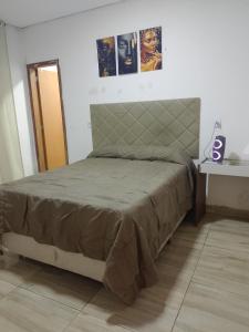 a bed in a white room with a bed frame at Casa Andreia Borges in Aparecida de Goiania +9 photos