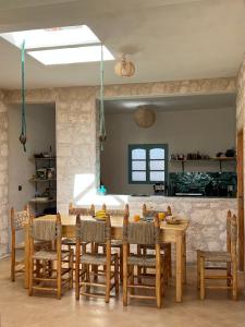 a dining room with a wooden table and chairs at Turquoise Brick Surf House in Essaouira