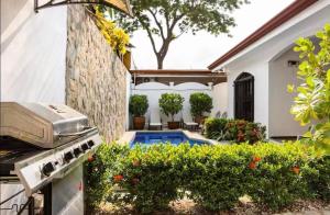 une arrière-cour avec un grill et une piscine dans l'établissement Casa La Perla del Océano, à Herradura