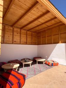 a room with two tables and two couches at Turquoise Brick Surf House in Essaouira
