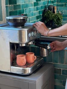a coffee maker on a counter with two cups at Turquoise Brick Surf House in Sidi Kaouki +16 photos