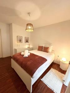 une chambre avec un grand lit et un lustre dans l'établissement Logement 2 pièces cosy avec parking privé, à Strasbourg