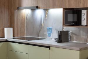 a kitchen with a sink and a microwave at Velunia Residence in Baia Mare