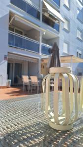 een witte stoel op een terras met een parasol bij Cambrils Puerto in Cambrils