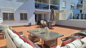 een terras met een tafel, stoelen en een parasol bij Cambrils Puerto in Cambrils