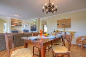 a dining room and living room with a wooden table and chairs at Villa Flor by Villa Plus in Guia