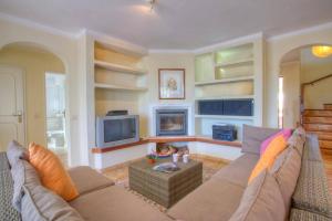 a living room with a couch and a tv at Villa Flor by Villa Plus in Guia
