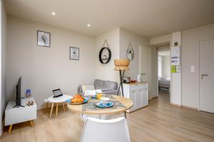 a living room with a table and a couch at Le 62-Appart'Hôtel-GregIMMO in Vieux-Charmont +23 photos