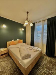 Una cama grande en un dormitorio con una ventana grande. en Pensiunea Elis, en Pescari