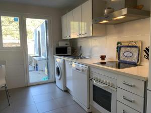 uma cozinha com uma máquina de lavar roupa, um lavatório e uma máquina de lavar louça em Casa Rural Nacimiento del Hueznar - Tomillo 17 em San Nicolás del Puerto mais 33 fotografias