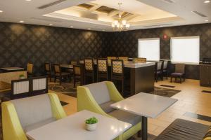 ポート・オレンジにあるLa Quinta by Wyndham Port Orange / Daytonaのテーブルと椅子とバーのあるレストラン +58枚の写真