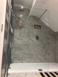 eine Dusche mit Glastür im Badezimmer in der Unterkunft Apartment Bushmills Hideaway Parking Pets Allowed in Bushmills