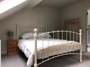 ein Schlafzimmer mit einem weißen Bett und einer Holzkommode in der Unterkunft Apartment Bushmills Hideaway Parking Pets Allowed in Bushmills