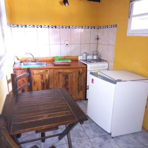 a kitchen with a table and a white refrigerator at Cabañas Los Nonos in El Bolsón +34 photos